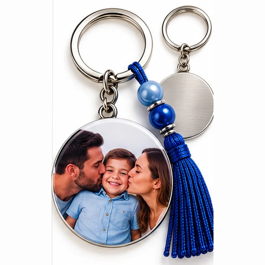 Chaveiro personalizado com foto de pai e mãe beijando o filho, com pingente de franja azul e o verso prateado ao lado